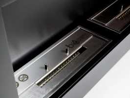 Brede zwarte biohaard met twee branders voor aan de muur.