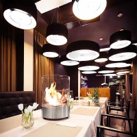 Cilindervormige biohaard met modern uiterlijke door glas en staal.