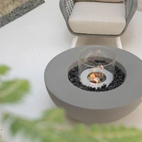 Ronde grijze bio-ethanol vuurtafel met bronzen glaskiezels en windscherm
