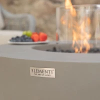 Ronde grijze bio-ethanol vuurtafel met bronzen glaskiezels en windscherm