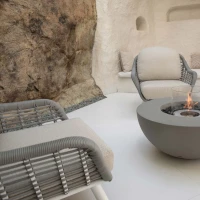 Ronde grijze bio-ethanol vuurtafel met bronzen glaskiezels en windscherm